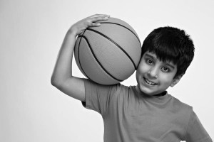 Portrait of a boy holding a basket ball and smiling